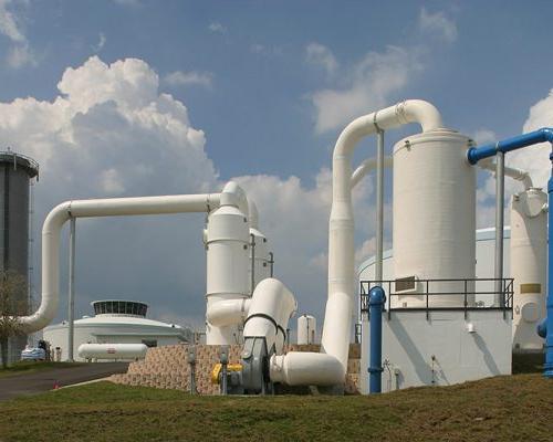 Large white storage tanks and piping outside the SMRU 水 Treatment Facility